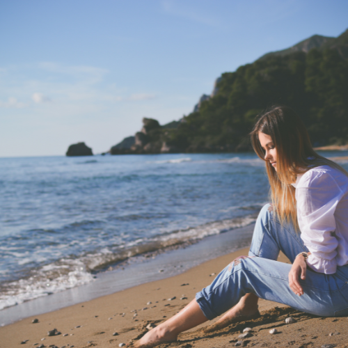 海辺で佇んでいる女性の写真