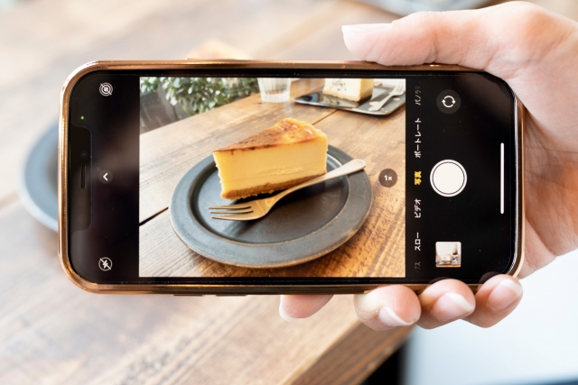 ケーキをスマホのカメラで撮っている画像